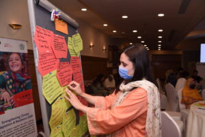 A participant pinning her ideas to the mood board during an activity
